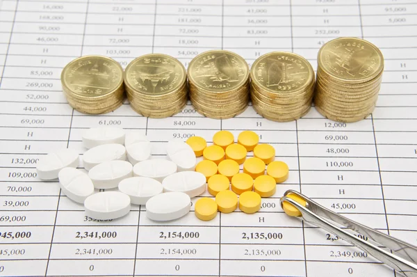Pinzette kneift Pille mit Schrittstapel von Goldmünzen — Stockfoto
