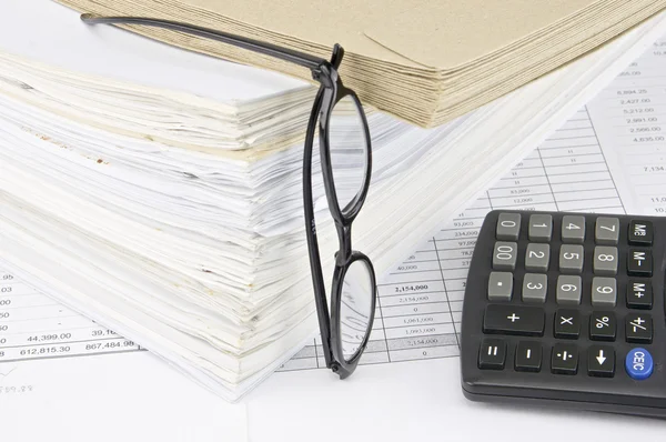 Envelope on overload old paperwork with vertical spectacles and calculator — Stock Photo, Image