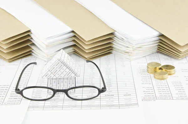 Spectacles and house with pile of gold coins — Stock Photo, Image