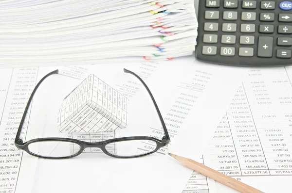 Brown pencil with spectacles and house on balance sheet — Stock Photo, Image