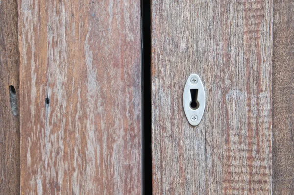 Aged old key hole on opened wooden door — Stock Photo, Image