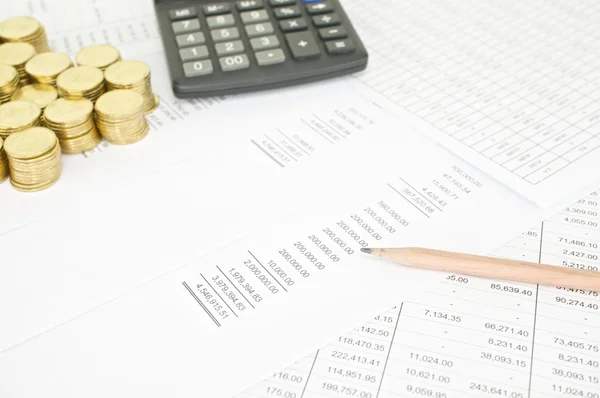 Pencil on finance account with pile of gold coins — Stockfoto