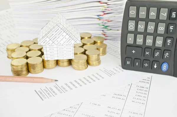 Pencil with house on gold coins and calculator place vertical — Stock Photo, Image