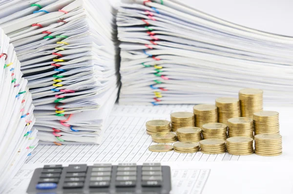 Passo moedas de ouro tem calculadora borrão como primeiro plano — Fotografia de Stock