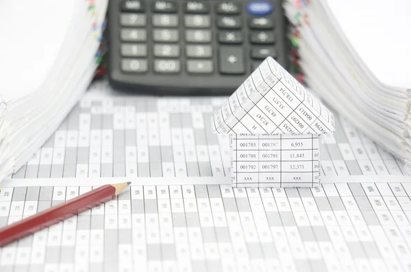 Lápiz marrón y casa en cuenta de finanzas con calculadora de desenfoque —  Fotos de Stock