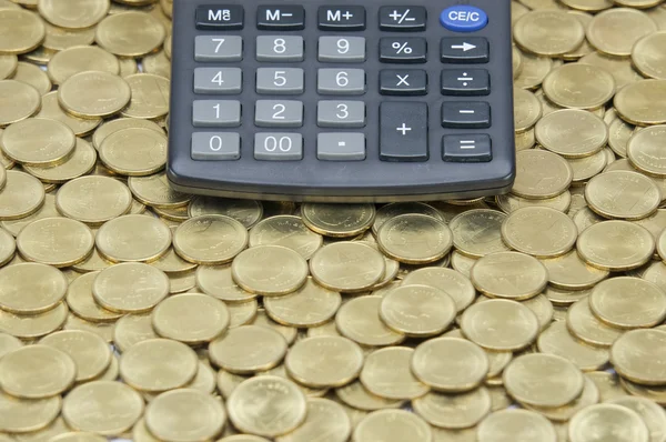 Black calculator on stack of gold coins — Stock Photo, Image