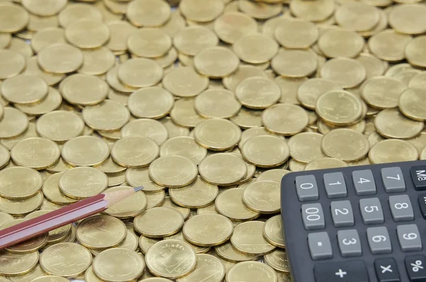 Lápiz marrón con calculadora negra en pila de monedas de oro —  Fotos de Stock