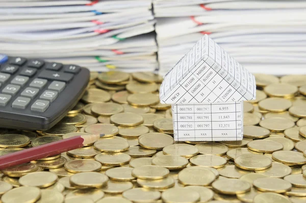 Potlood en rekenmachine met huis op stapel van gouden munten — Stockfoto