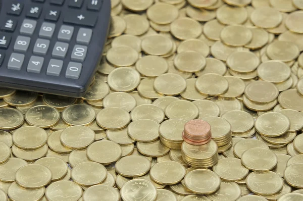 Купа мідних монет з калькулятором на стокових золотих монетах — стокове фото