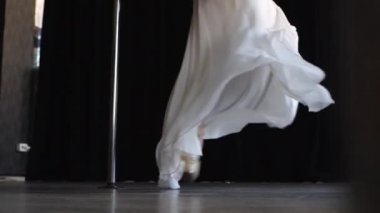 Pilonun üstünde dans eden narin bir kadın.