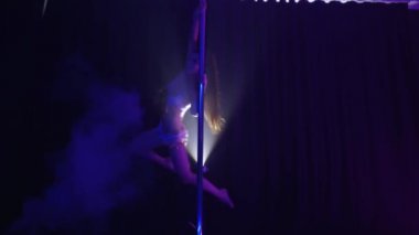 Pilonun üstünde dans eden narin bir kadın.