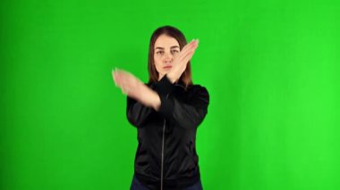 Yeşil ekranda kollarını kavuşturan bir kadın.