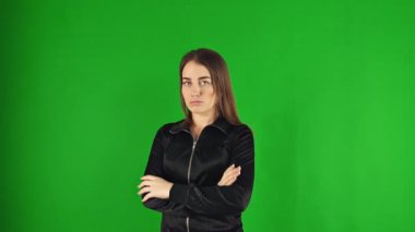 Kollarını çapraz yapmış, yeşil ekranda izole edilmiş genç bir kız.