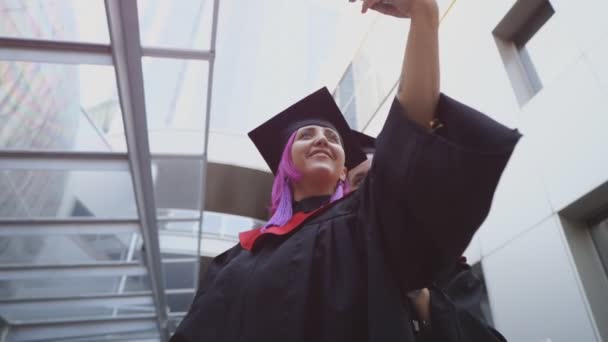 Dos afortunados graduados se toman selfies — Vídeo de stock
