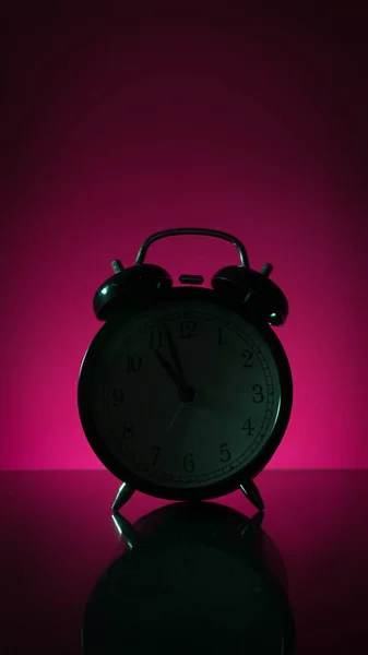 Pembe arka planda çalar saat silueti