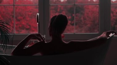 Güzel bir kadın Japonya 'da çiçek açan Sakura bahçesi manzaralı bir banyodan hoşlanıyor.