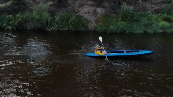 Un jeune homme fort flotte dans un kayak en vue latérale — Video