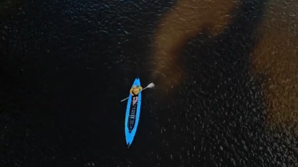 Un jeune homme fort nage dans un kayak bleu. Vue du dessus — Video