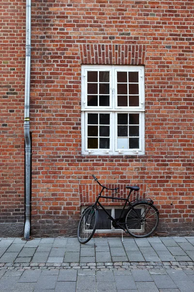 Black bicycle from an old brick wal — Stock Photo, Image