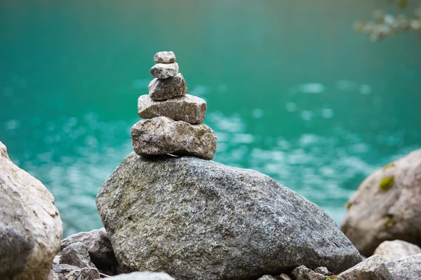 Cairn on the shore of a mountain lake — Stock Photo, Image