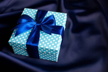 Mavi arka planda fiyonklu mavi hediye kutusu. Tatil tebrik kartı..