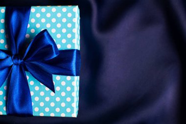 Mavi arka planda fiyonklu mavi hediye kutusu. Tatil tebrik kartı..