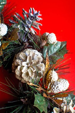 Kırmızı arka planda Noel çelengi var. Noel tebrik kartı..