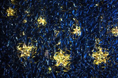 Klasik mavi arka planda parıldayan altın yıldızlar. Yeni yıl ve Noel konsepti.