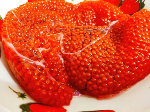 Red caviar of trout in a white plate. Salmon roe on a plate. A lot of large salmon caviar on plate. — Stock Photo, Image