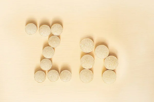 Medizinflasche mit Tabletten. Pillen aus der Flasche auf dem Pfirsichhintergrund. Bierhefe mit Zink. — Stockfoto