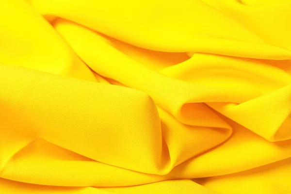 Beautiful yellow satin as a background, soft yellow abstraction. Selective focus. Color 2021.