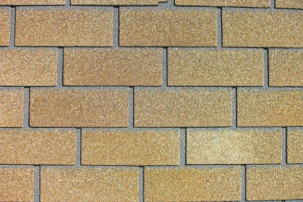 Brown wall tiles imitating brickwork. Modern finishing material. Close-up of exterior facade decoration. Stock Photo
