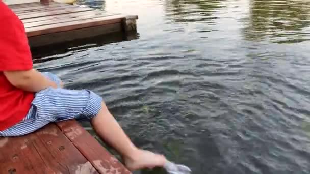 Little Boy Sitting Bridge Splashing Water Feet — Stock Video