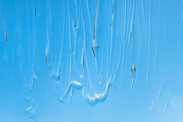 Liquid cosmetic gel on blue background. Hand antibacterial gel. — Stock Photo, Image