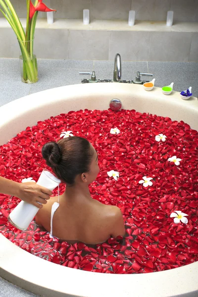 Cuidado corporal femenino en baño con pétalo de rosa —  Fotos de Stock