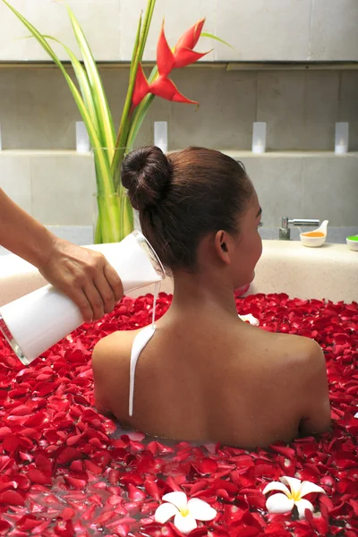 Cuidado do corpo feminino no banho com pétala de rosa — Fotografia de Stock