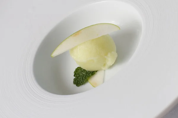 Apple sorbet serveras i en vit skål Stockfoto