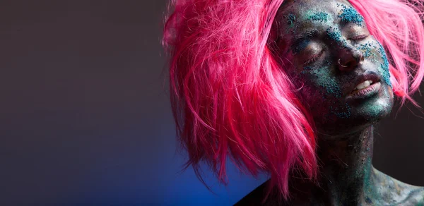 Mulher com cabelo de peruca rosa e arte facial — Fotografia de Stock