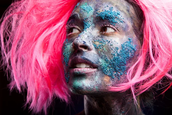 Mulher com cabelo de peruca rosa e arte facial — Fotografia de Stock