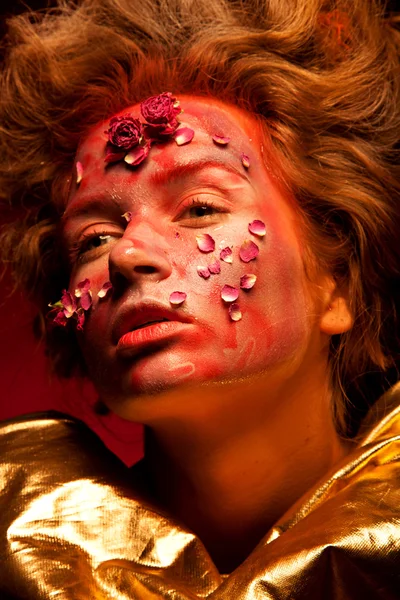 Ragazza con colore rosso e oro faccia arte — Foto Stock