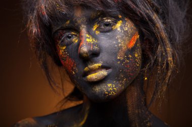 Yüzündeki kırmızı ve sarı boya