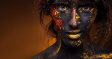 Yüzündeki kırmızı ve sarı boya