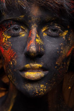 Yüzündeki kırmızı ve sarı boya