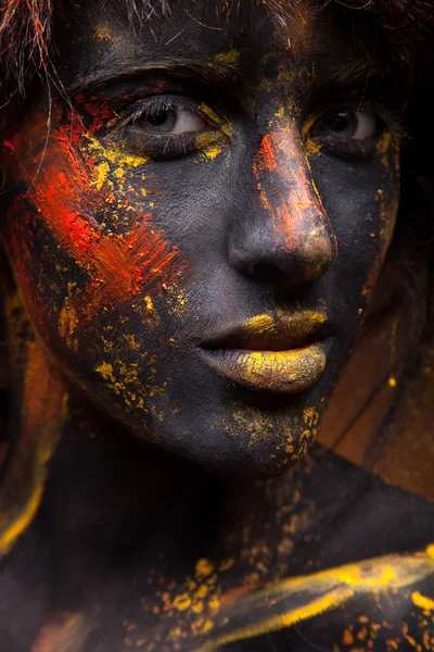 Yüzündeki kırmızı ve sarı boya