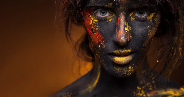 Pintura roja y amarilla en la cara — Foto de Stock