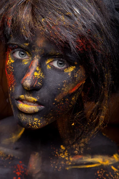 Tinta vermelha e amarela no rosto — Fotografia de Stock