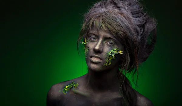 Vrouw met zwart gezicht en groen gezicht kunst — Stockfoto