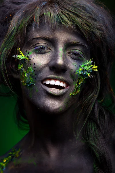 Woman with black face and green face art — Stock Photo, Image