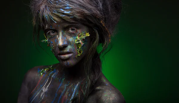 Woman with black face and green face art — Stock Photo, Image