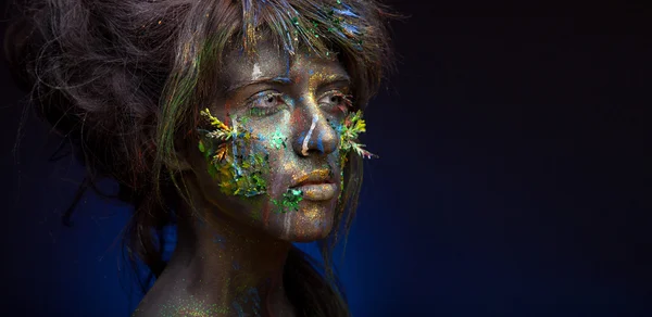 Woman with black face and green face art — Stock Photo, Image